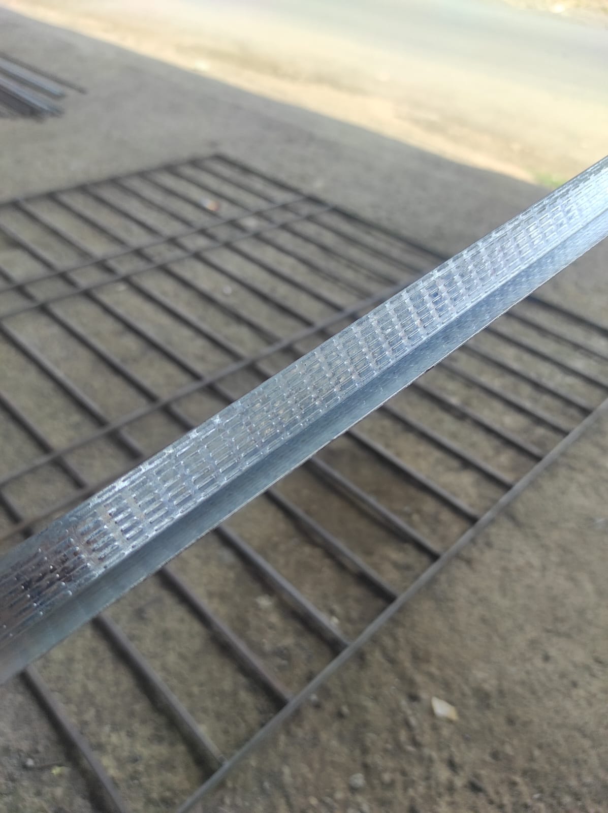 Galvanized steel L-angle lying flat on surface